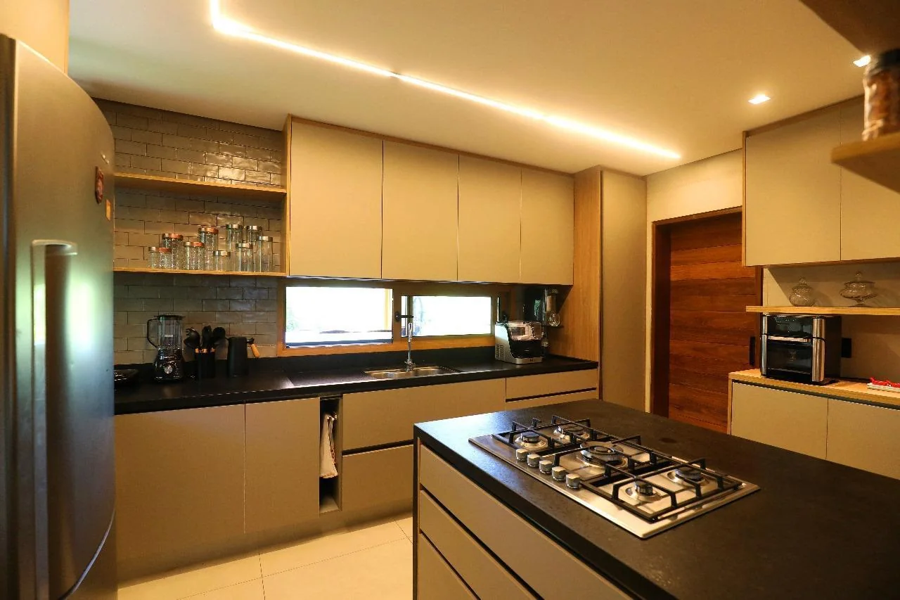 Cozinha com ilha central, bar e marcenaria sob medida