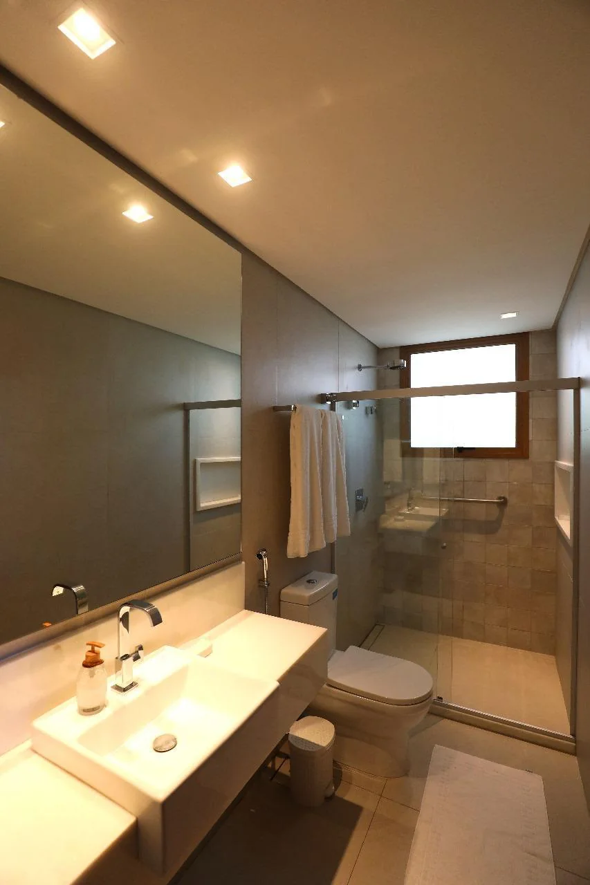 Banheiro em mármore com bancada e ducha